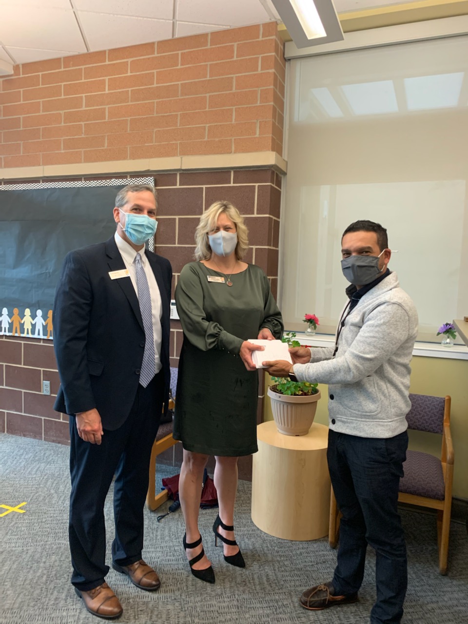 Presenting Mr. Melendez, Principal at Dickinson Academy in Grand Rapids, with Amazon gift cards for all the teachers at the school.